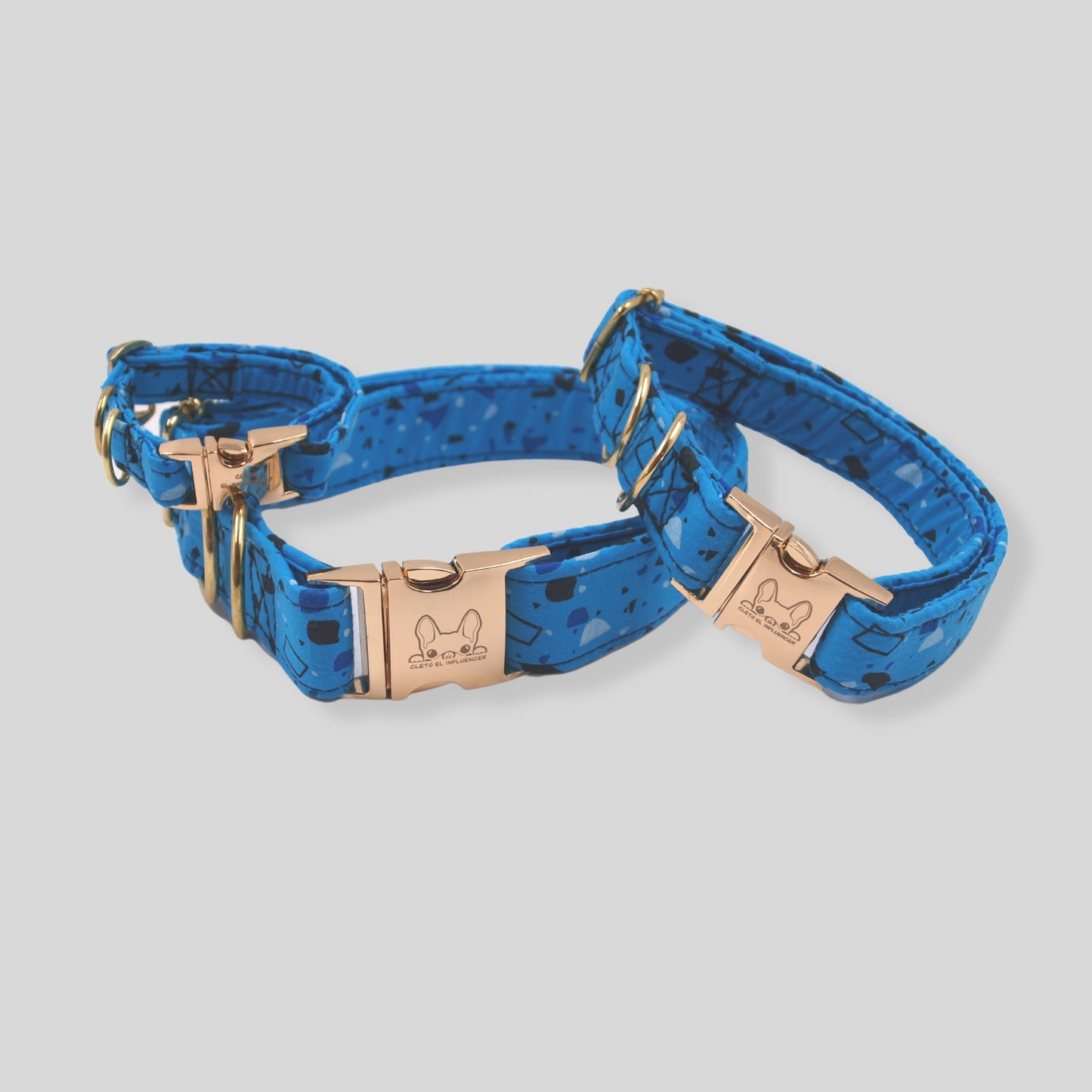 Collares para mascota con herrajes dorados, el collar es azul con formas geométricas en tonos azules.